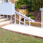 Folded Dorado Inclined Lift at the top of a small set of stairs leading down to a garden with a path
