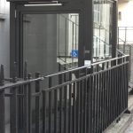 Black hydraulic lift inside of black railings