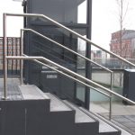 black hydraulic lift next to a set of stairs with metal railings