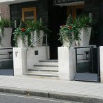 Mira low-rise platform lift outside a building with plant pots