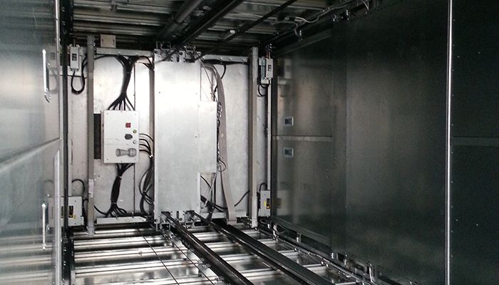 Interior of an attended goods lift showing the rails and control system
