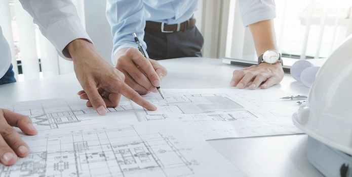 Architects working on floor plans for lift installation