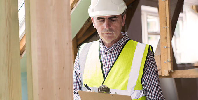 A construction worker examining a health and safety checklist on a construction project